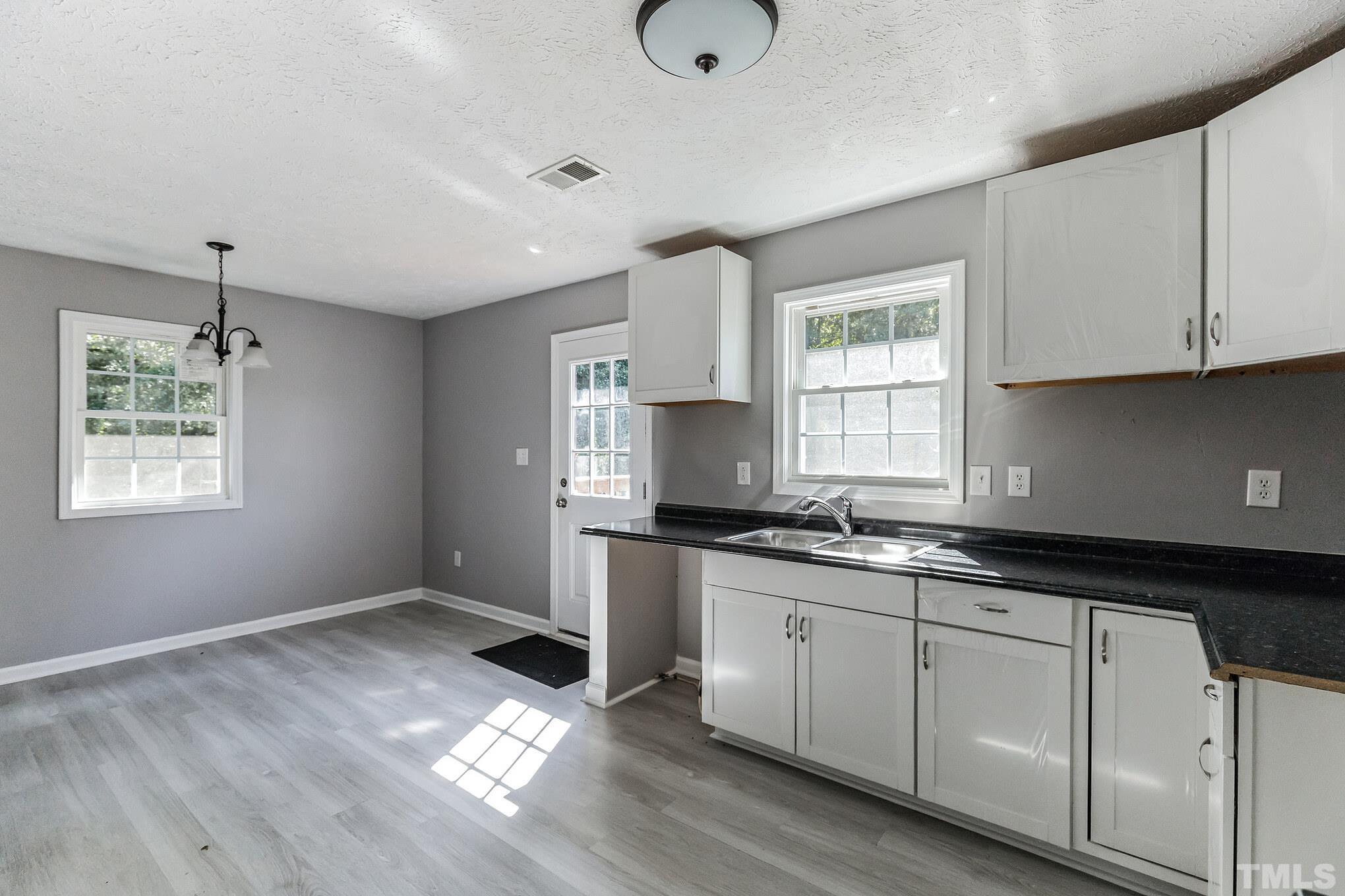 3763 Waycross Road Magnolia, NC 28453 - Photo 19 of 34 a kitchen with granite countertop white cabinets and window