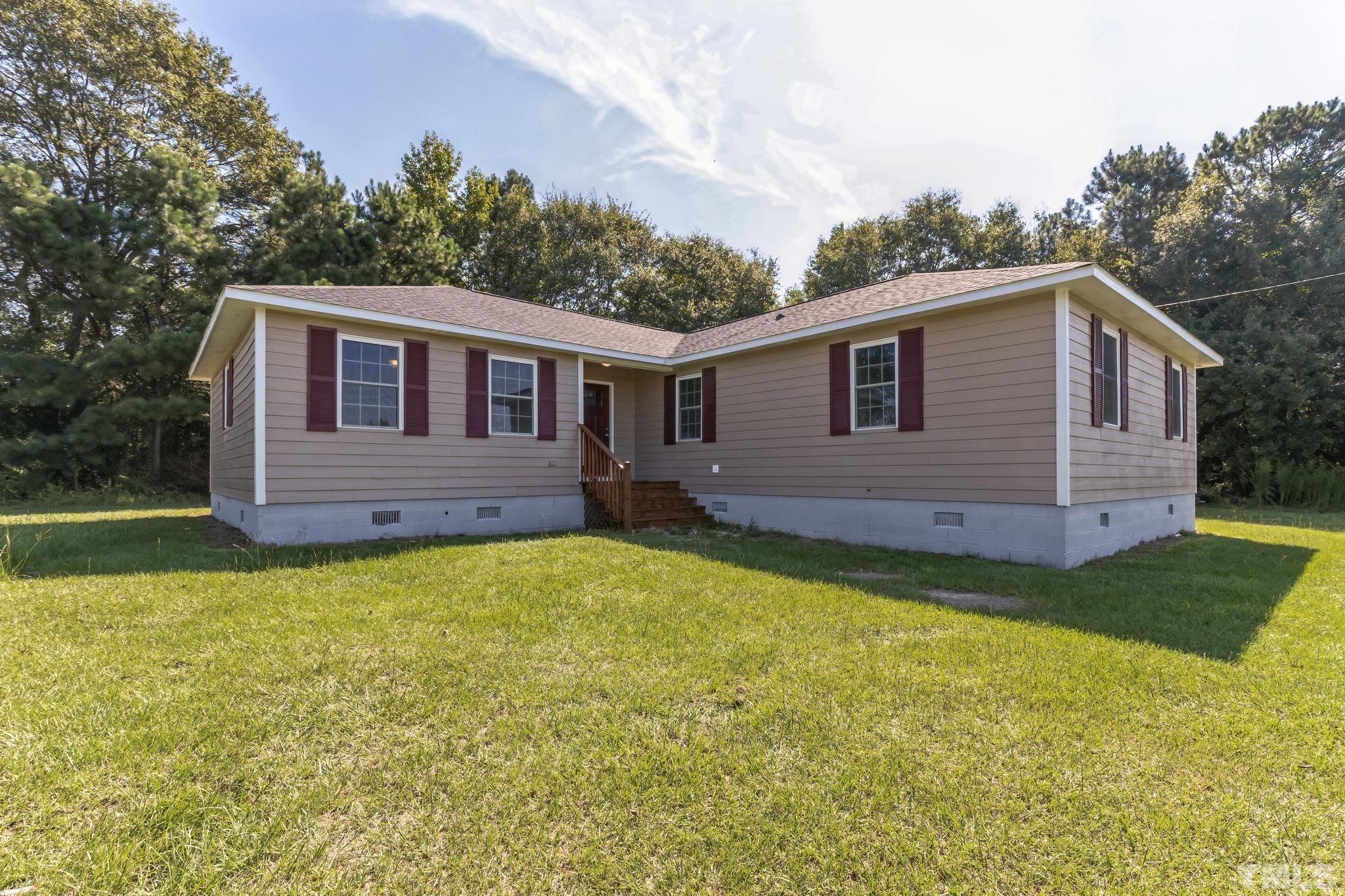 3763 Waycross Road Magnolia, NC 28453 - Photo 24 of 34 a front view of a house with a garden