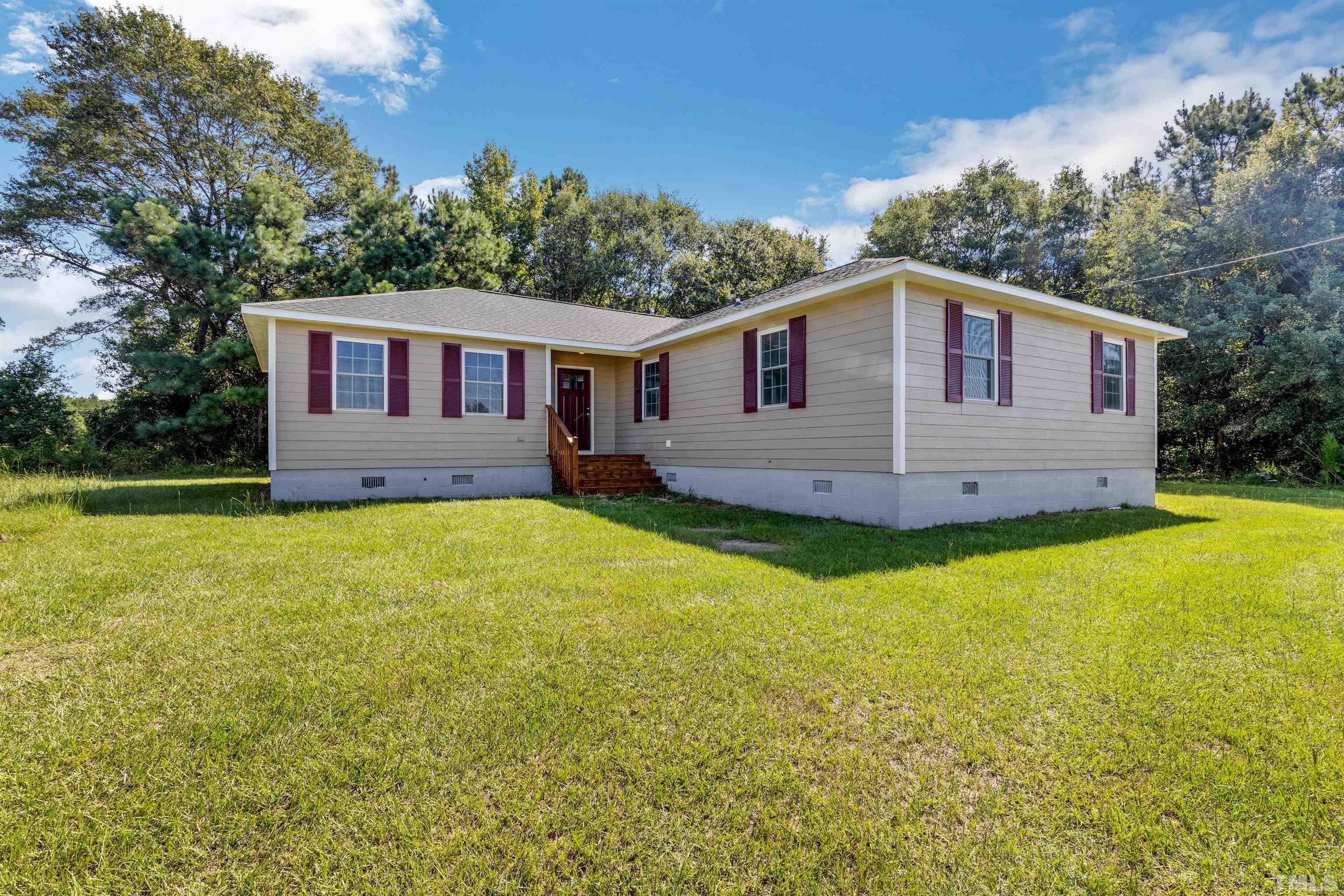 3763 Waycross Road Magnolia, NC 28453 - Photo 27 of 34 a front view of house with yard and trees in the background