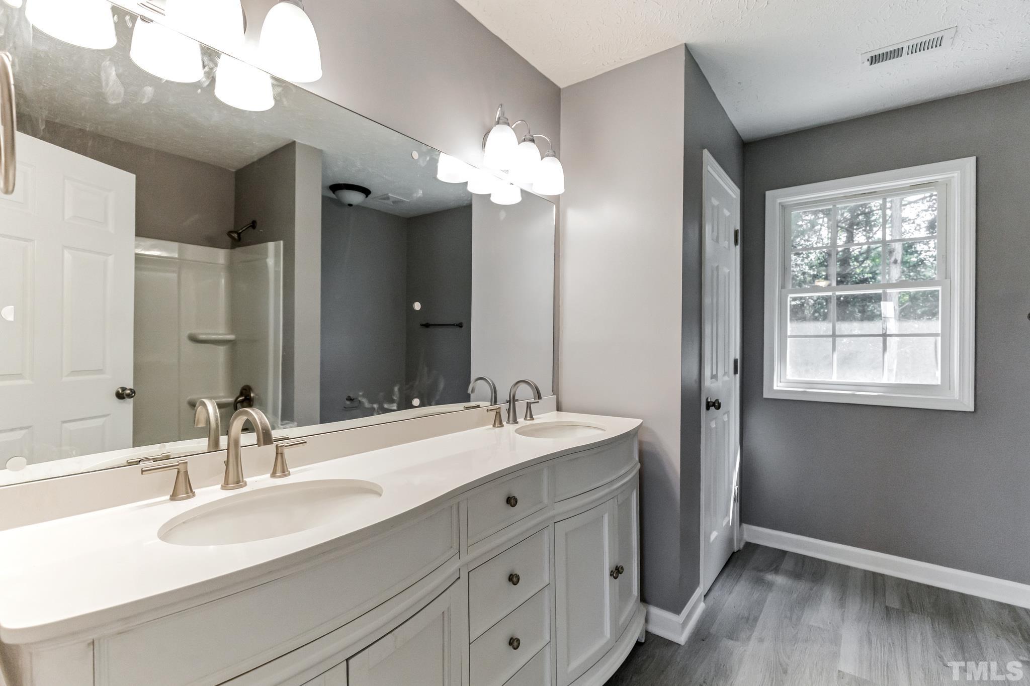 3763 Waycross Road Magnolia, NC 28453 - Photo 5 of 34 a bathroom with a double vanity sink and a mirror