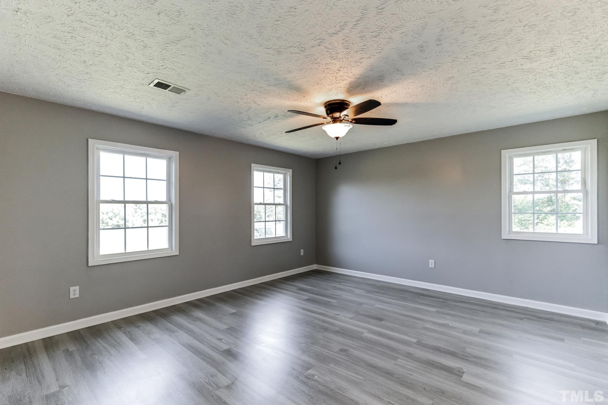 3763 Waycross Road Magnolia, NC 28453 - Photo 7 of 34 a view of an empty room with a window and wooden floor