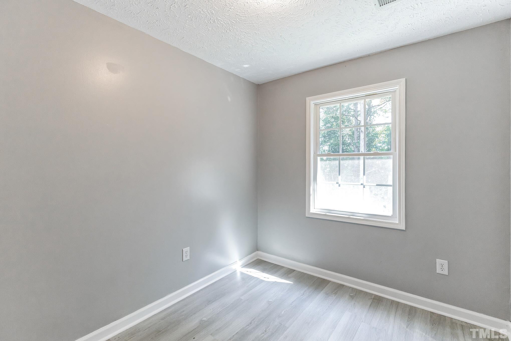 3763 Waycross Road Magnolia, NC 28453 - Photo 9 of 34 an empty room with wooden floor and windows