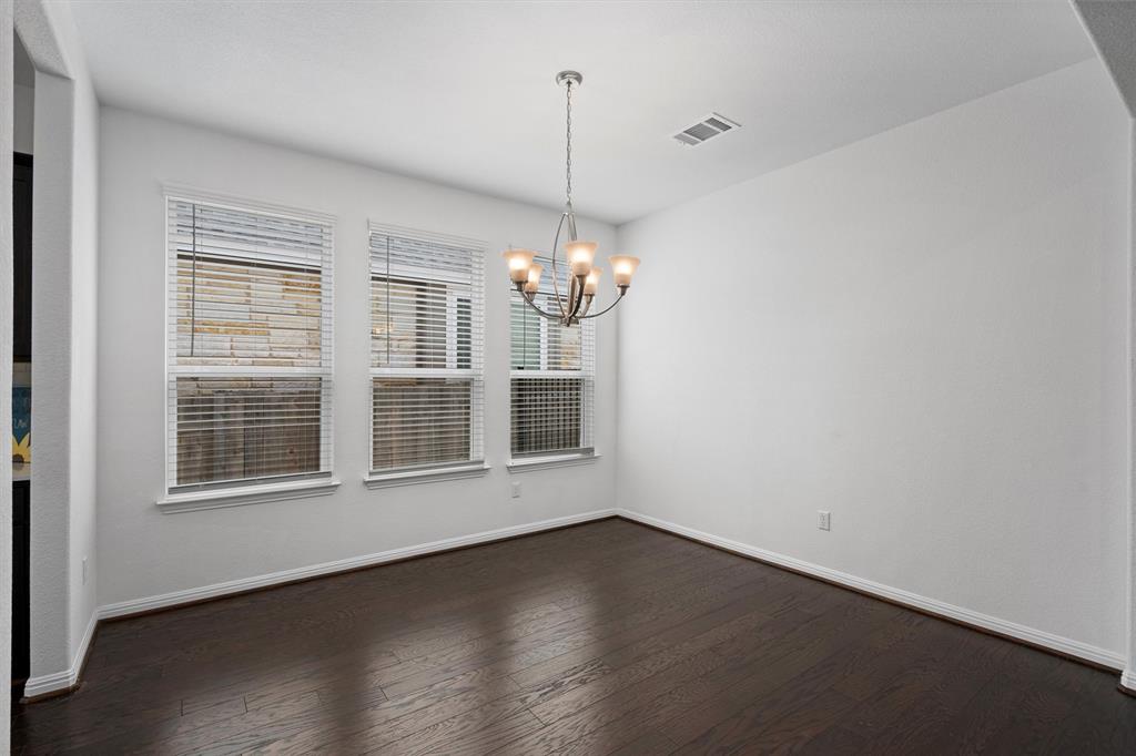 236 Prato Place Georgetown, TX 78628 - Photo 9 of 40 Rich hardwood floors complement the classic chandelier in this inviting dining space.