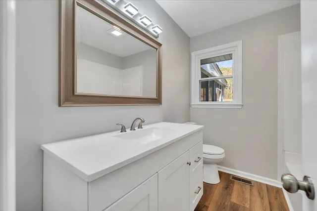 an empty room with wooden floor and fireplace