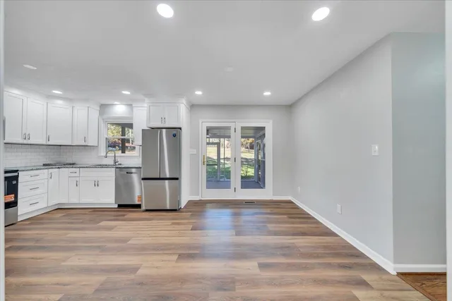 a kitchen with granite countertop white cabinets and white appliances
