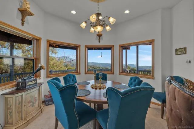 a dining room with furniture a large window and a chandelier