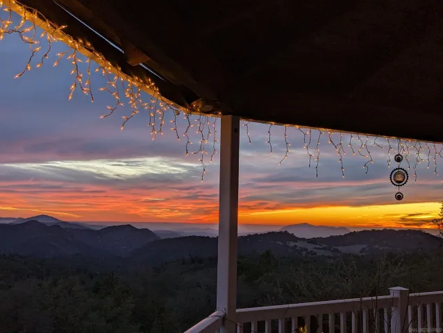 a view of a dry yard with wooden fence