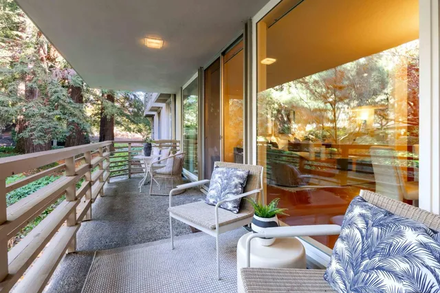 a living room with patio furniture and a floor to ceiling window
