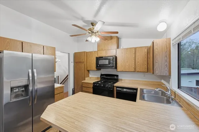 a kitchen with stainless steel appliances a refrigerator sink and microwave