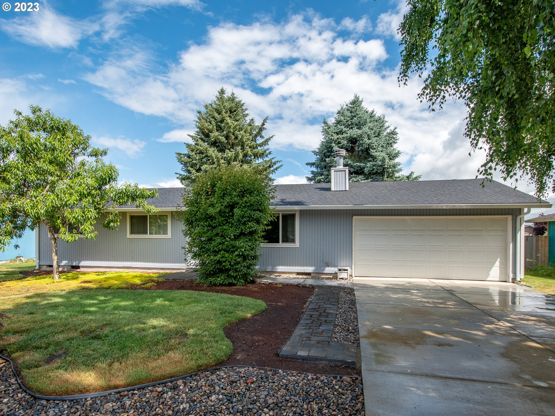 5208 Northeast 139th Loop Vancouver, WA 98682 - Photo 34 of 37 a view of a white house with a yard potted plants and large tree