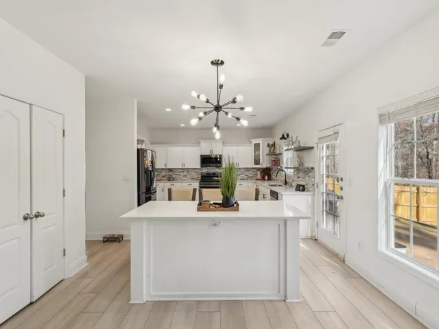a view of kitchen with refrigerator stove and wooden floor