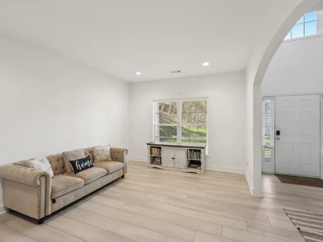 a living room with furniture a window and a flat screen tv
