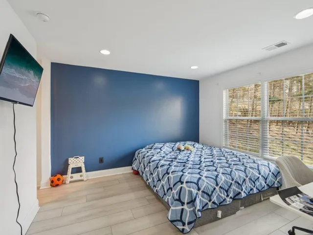 a bedroom with a bed and wooden floor