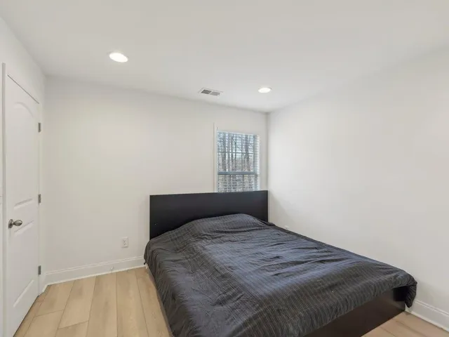 a spacious bedroom with a bed and a window