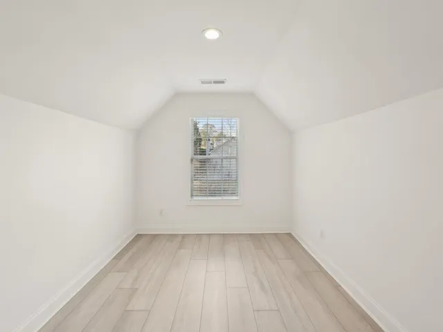 a view of a room with wooden floor and a hallway