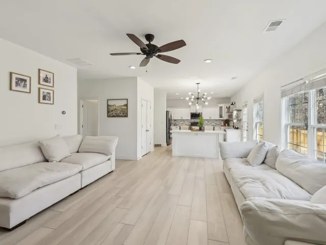 a living room with furniture and a view of kitchen