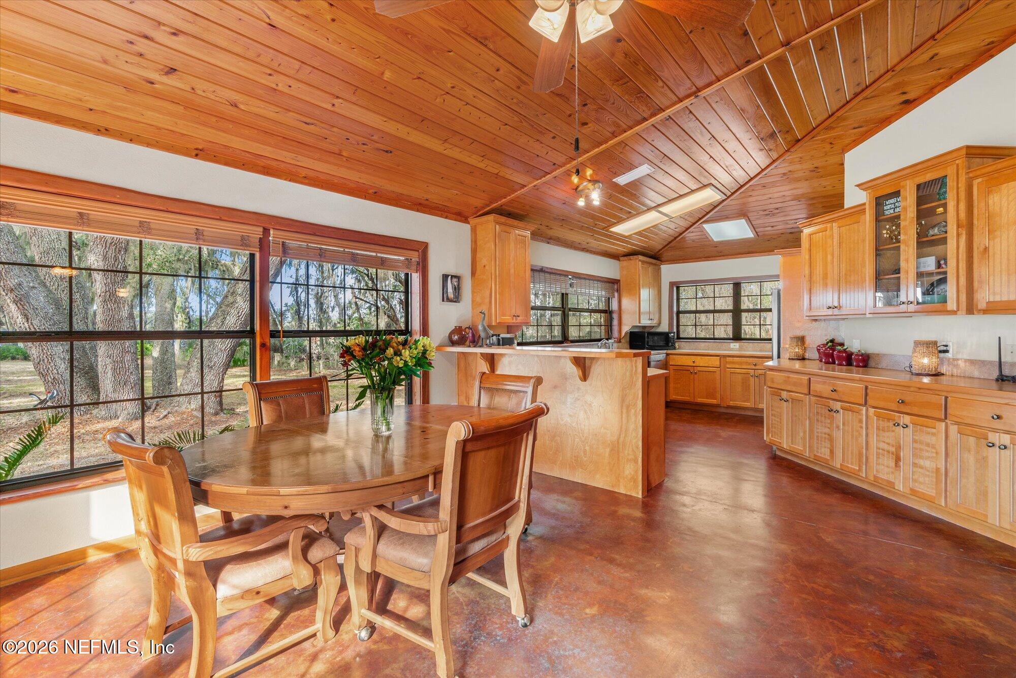 118 Hooks Lake Road Melrose, FL 32666 - Photo 15 of 61 a dining room with furniture a kitchen view and large windows