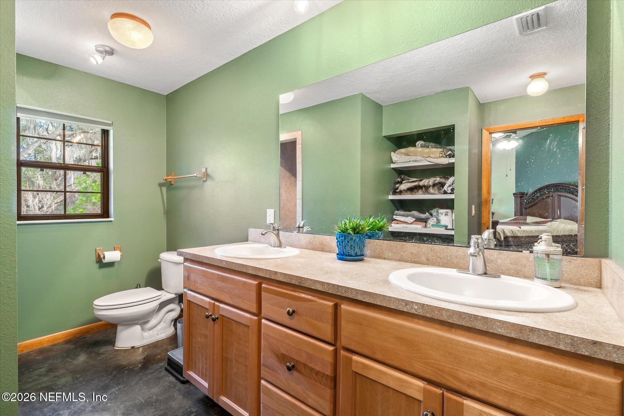 118 Hooks Lake Road Melrose, FL 32666 - Photo 27 of 61 a bathroom with a granite countertop toilet sink and mirror