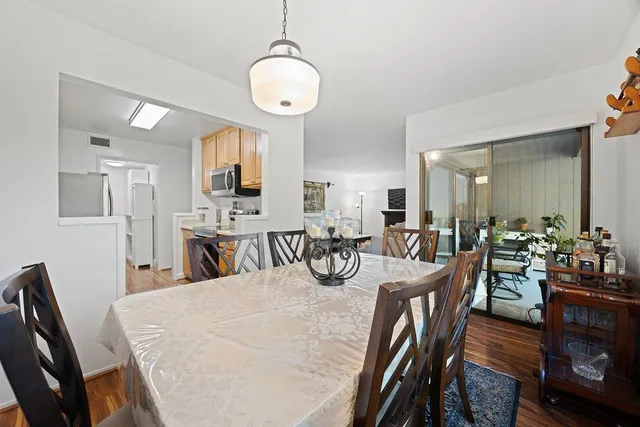 a view of a kitchen with a refrigerator and wooden floor