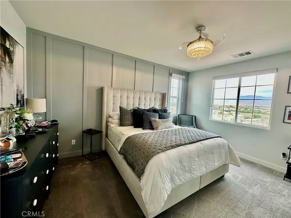 a bedroom with a bed and a chandelier