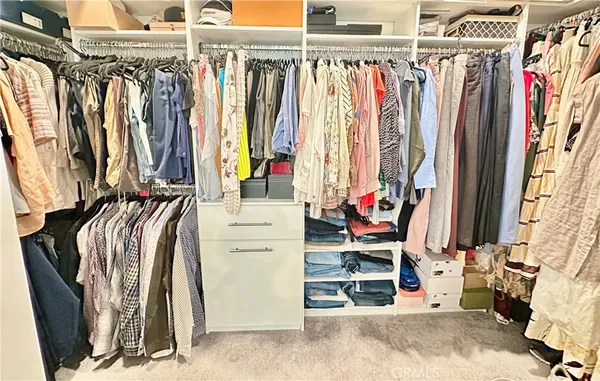 a view of walk in closet with clothes