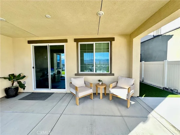 a balcony with couple of chairs and a couch
