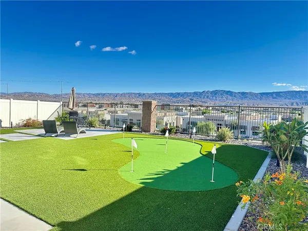 a view of a swimming pool with lawn chairs and plants