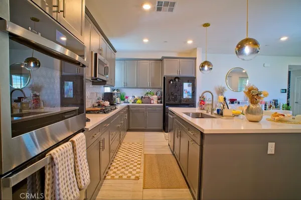 a kitchen that has a lot of cabinets and wooden floor