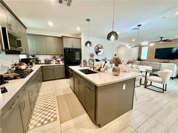 a kitchen with a sink and a stove top oven with wooden floor