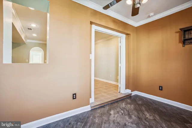 an empty room with wooden floor and mirror