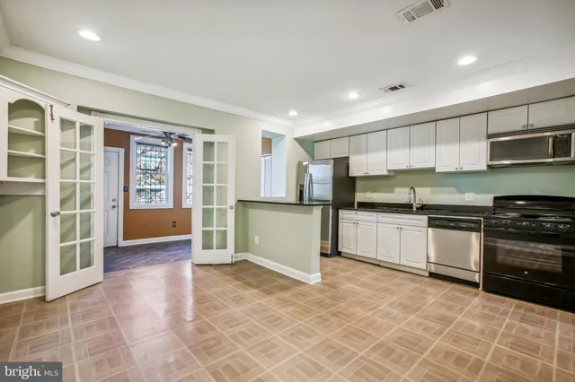 a kitchen with stainless steel appliances granite countertop a refrigerator and a stove top oven