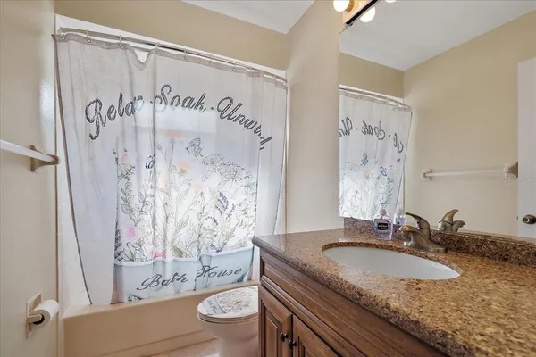 a bathroom with a granite countertop sink a toilet and a bathtub