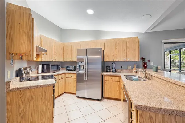 a kitchen with stainless steel appliances granite countertop a sink stove refrigerator and cabinets
