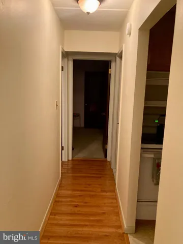 a view of a hallway with wooden floor and staircase