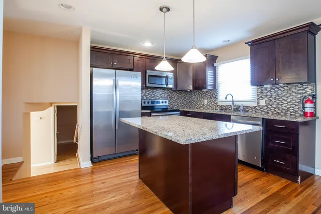 a kitchen with granite countertop cabinets a sink and stainless steel appliances