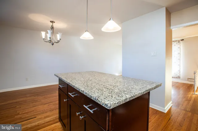 a kitchen with a sink chandelier and wooden floor
