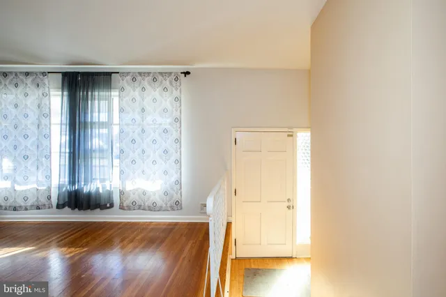 a view of a room with wooden floor and a window