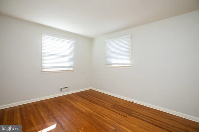 a view of a room with wooden floor and windows