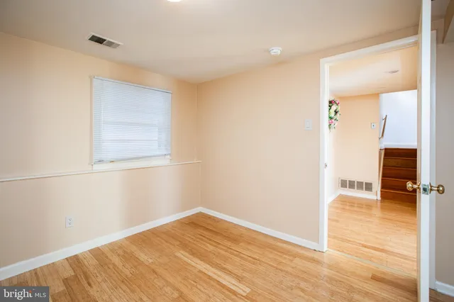 a view of empty room with wooden floor