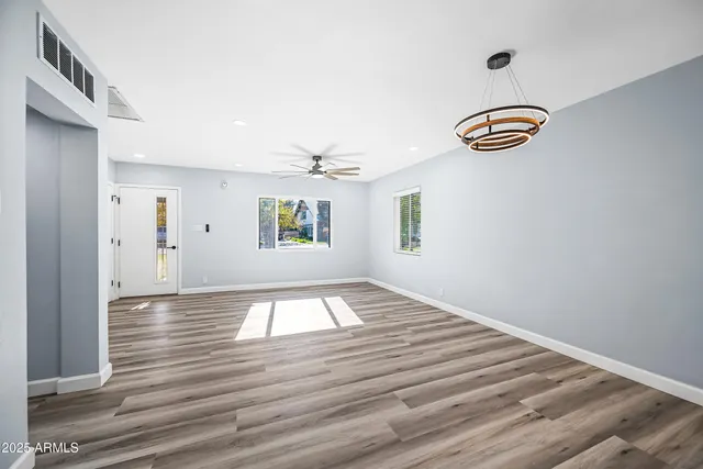 a view of empty room with wooden floor and window