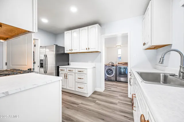 a kitchen with white cabinets and appliances