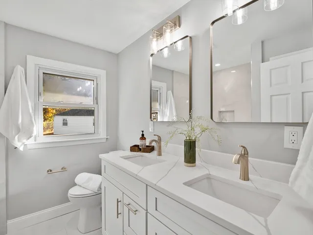 a bathroom with a toilet sink and mirror