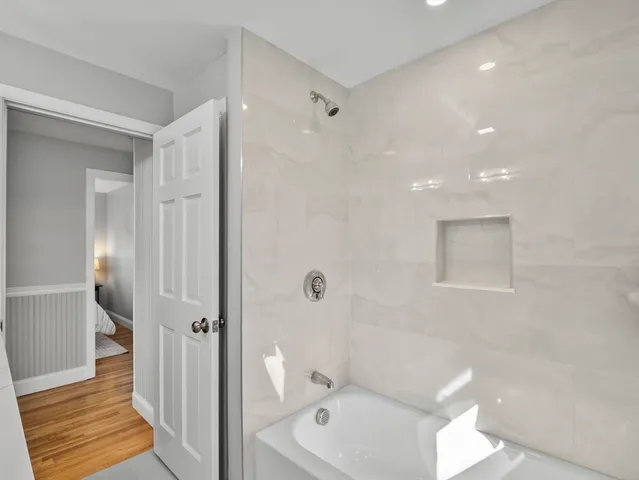 a bathroom with a tub shower and toilet