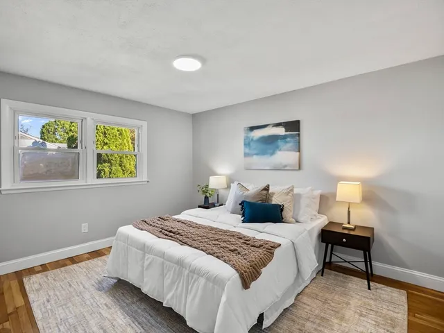 a bedroom with a bed and a lamp on dresser