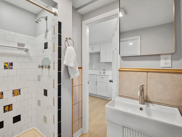 a bathroom with a sink a mirror and shower