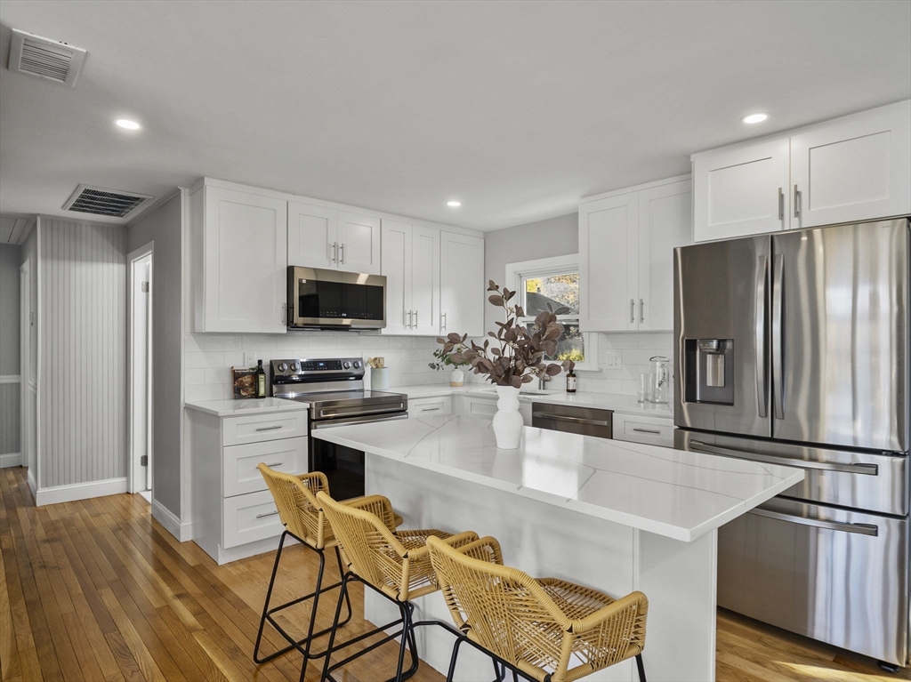 27 Hodgkins Road Rockport, MA 01966 - Photo 4 of 35 a kitchen with stainless steel appliances a refrigerator stove microwave and cabinets