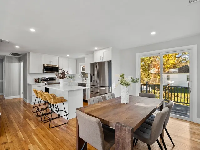 a kitchen with stainless steel appliances kitchen island granite countertop a dining table chairs and granite counter tops