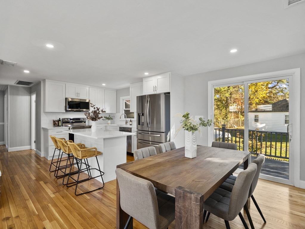 27 Hodgkins Road Rockport, MA 01966 - Photo 5 of 35 a kitchen with stainless steel appliances kitchen island granite countertop a dining table chairs and granite counter tops