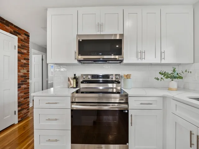 a kitchen with white cabinets and stainless steel appliances