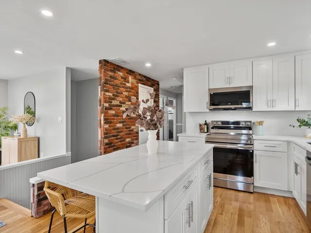 a kitchen with stainless steel appliances a stove a sink a microwave a refrigerator and cabinets